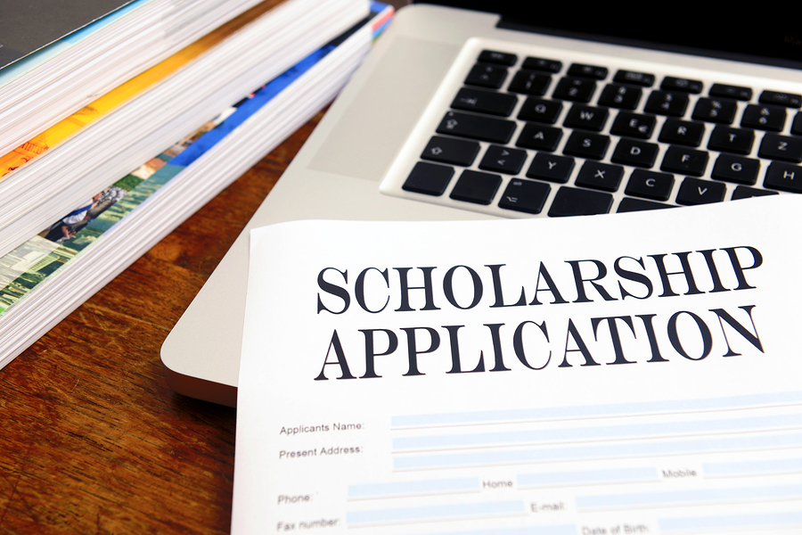 blank scholarship application on desktop with books and laptop